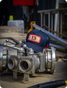 Fire hose valves with a #13 ballcap laid on top of them