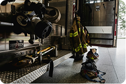 A fire engine parked at a station, with boots and jackets prepared.