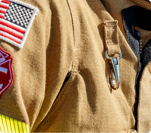 Close up of a firefighter's jacket, with flag and badge emblems on the arm