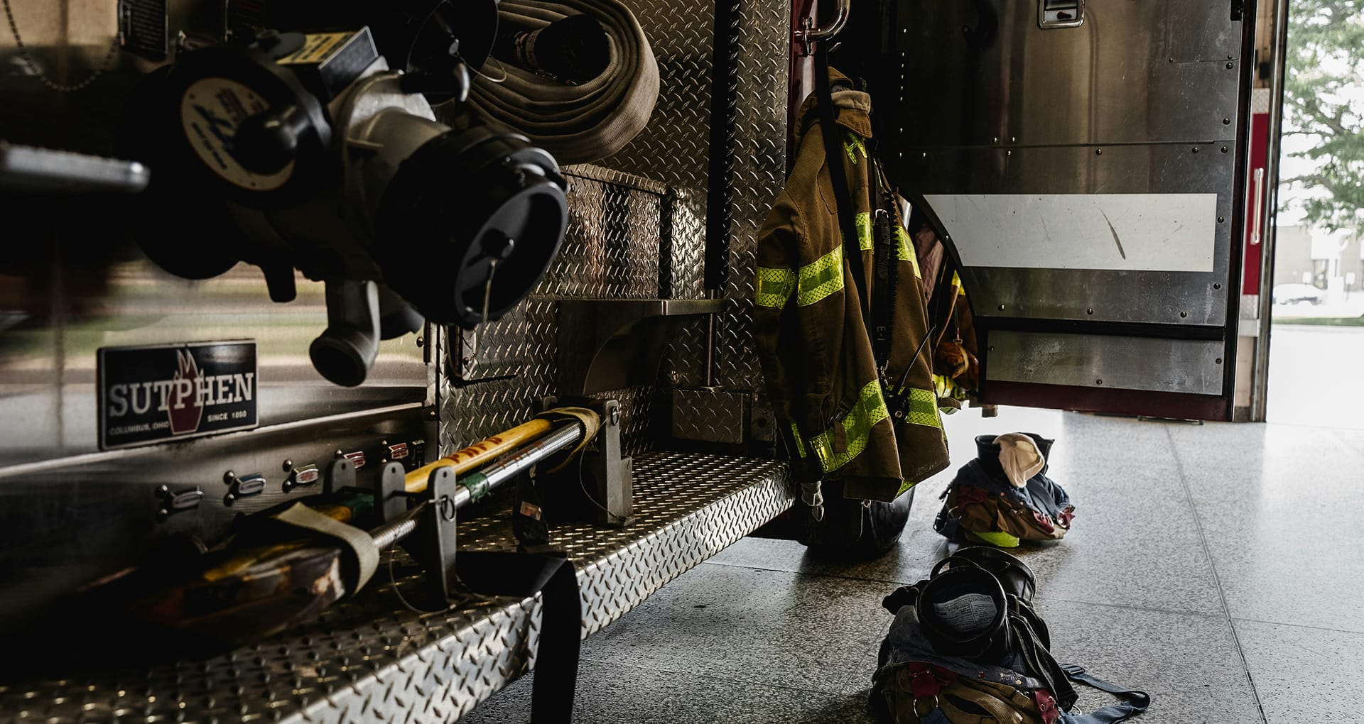a fire engine parked at a station, with boots and jackets prepared.