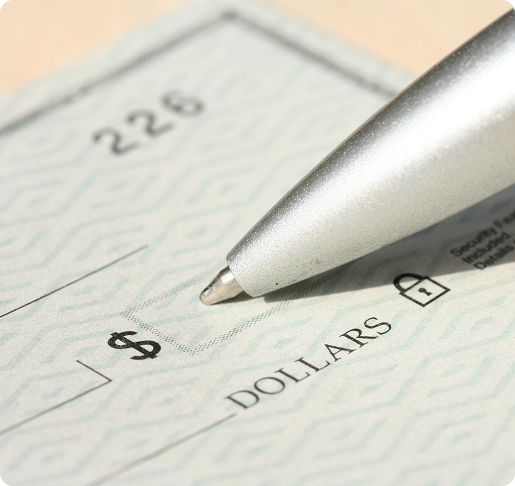 a closeup of a check, with a pen about to fill in the dollar amount