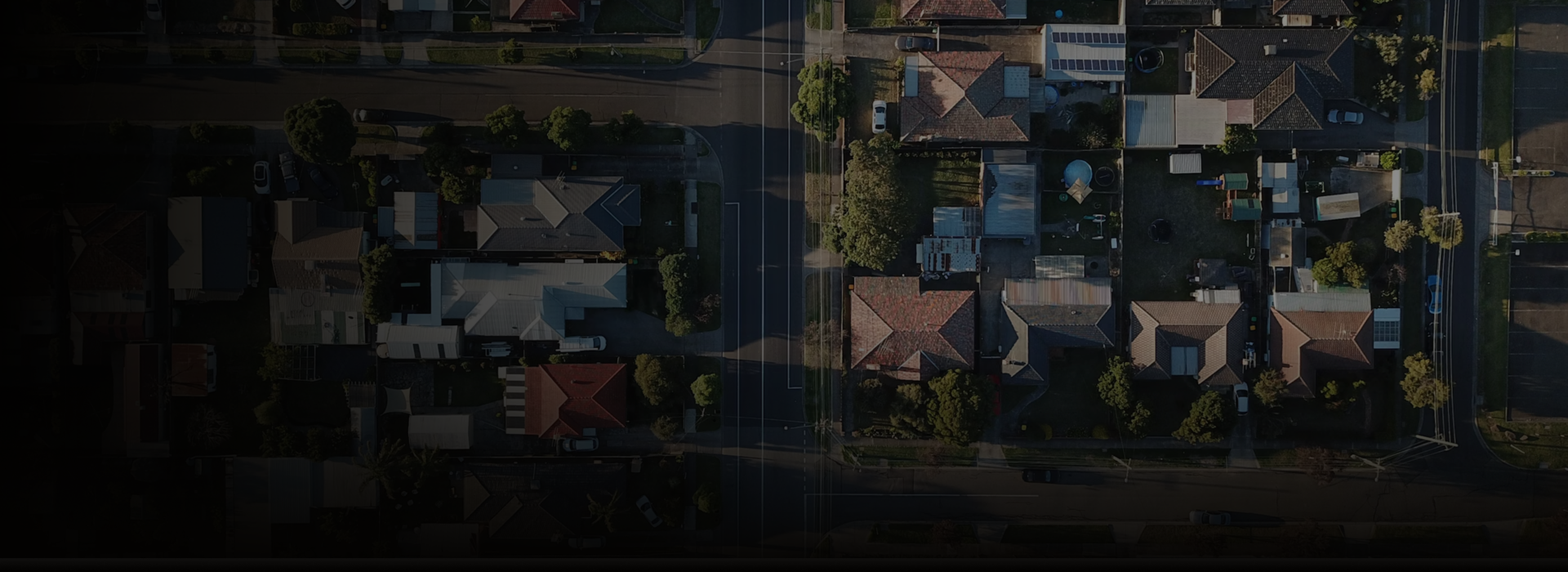 Aerial view of a residential neighborhood with rows of houses and streets.
