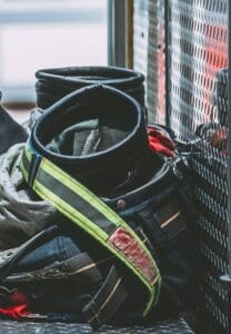 Firefighter turnout gear and helmet resting inside a fire apparatus compartment.