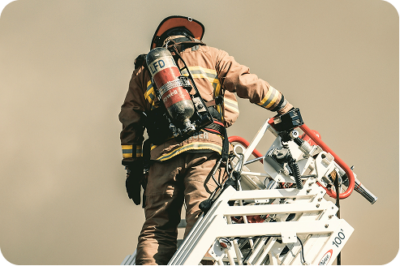 Firefighter in full gear operating equipment from an aerial ladder bucket