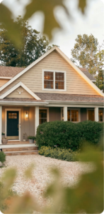 Warmly lit single-family home exterior at dusk with landscaped front yard