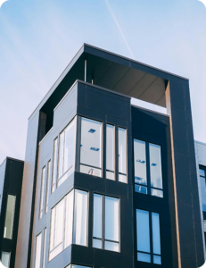 Exterior corner view of a modern multi-story commercial building against a blue sky