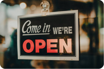 "Come in, we're open" sign displayed in a storefront window