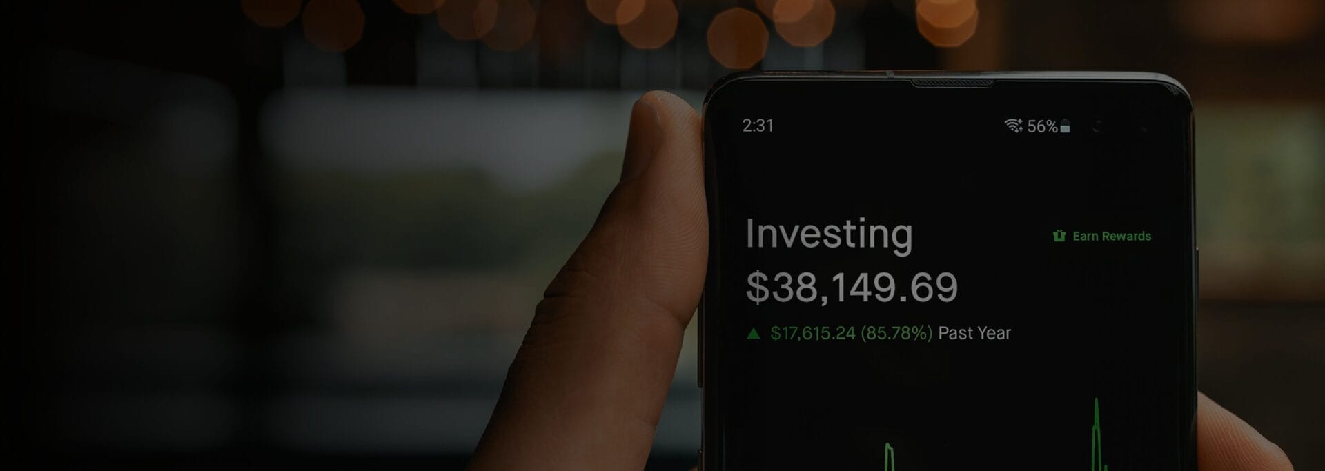 Hand holding an iPhone displaying an investment app.
