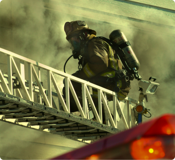 Fireman in full gear, on aerial ladder, with smoke surrounding him