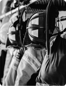 Black and white photo of helmets and jackets in the turnout room