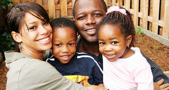 A family with two kids, smiling